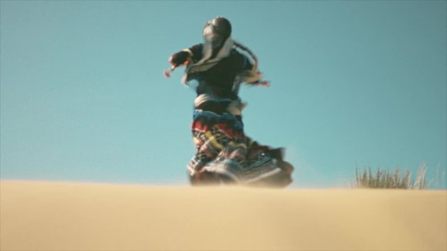 Gypsy woman dancing and spinning on a desert sand dune
