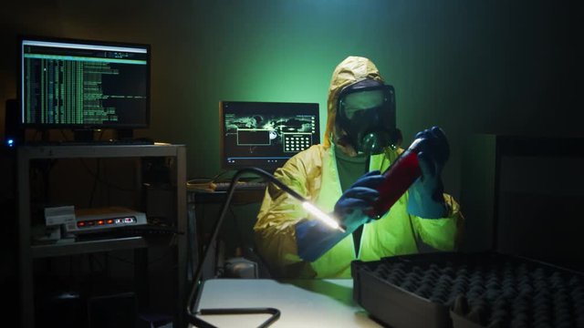 Bioterrorist examines a bottle of dangerous liquid