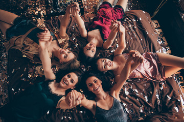 Top above high angle closeup view photo of five laughing excited pretty charming lovely cute multiethnic ladies lying down on soft linen having night before wedding meeting gathering entertainment