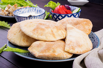 Pita stuffed with chicken, tomato and lettuce on wooden background. Middle Eastern cuisine.