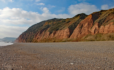 Fototapeta na wymiar The sandstone cliffs of the Jurassic era rising from Salcombe Regis beach
