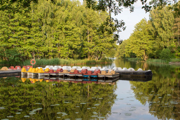 Water bikes, boats, canoes in the summer sunny day on the lake. Beautiful landscape and a great place to practice water sports on the water while on vacation.