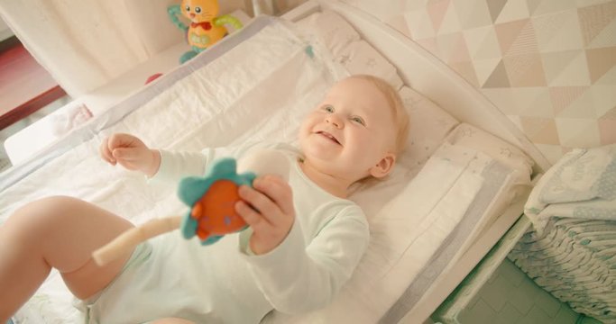 Happy Baby girl smiling at home on a changing mat