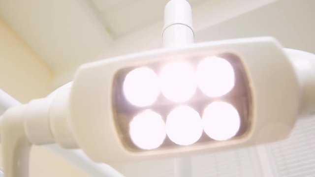 Fluorescent lamp for lighting in the dental office, hand movement.