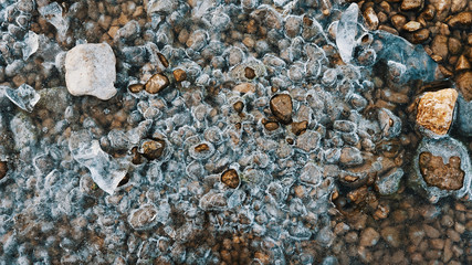 Small frozen stones in a river