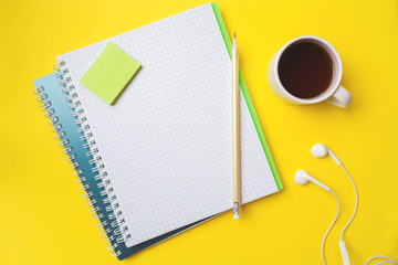 Clean white notebook and pencil Cup of coffee with copy space on yellow table background for...