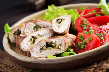 Delicious chicken rolls stuffed with cheese and spinach wrapped in strips of bacon.