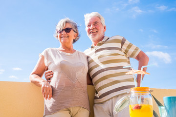nice couple of retired adult stay together on the roofto pterrace eating and drinking some food and...