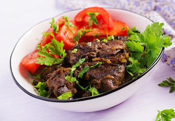 Roasted or grilled beef liver with onion and tomatoes salad. Middle Eastern cuisine.