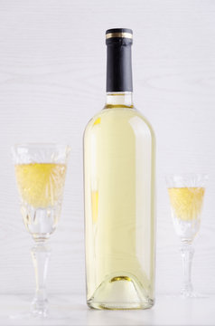 Two full glasses of wine and full bottle of wine on the white surface against bright background