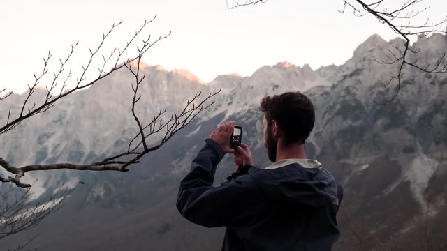 The famous and beautiful Valbona valley in the Albanian Alps. Hiking in the mountains during the fall season. Man taking photos of the mountains in Albania with a camera