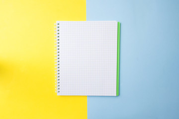 Clean white notebook and pencil with copy space on yellow blue table background for presentation,...