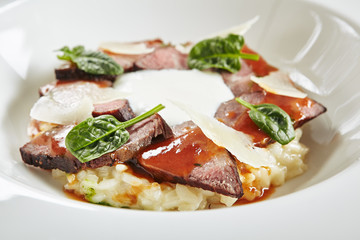 Exquisite Serving White Restaurant Plate of Risotto with Pecorino Cheese and Warm Roast Beef