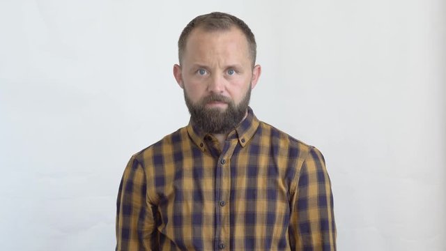 concept of emotions and feelings that we experience when dealing with people. close-up of an attractive bearded man in a plaid shirt on a white background a gesture showing his consent