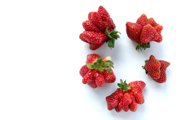 Ugly strawberries on white background.