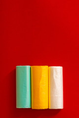 Colored garbage bags roll on gray background