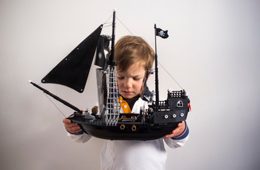 3 years boy observing his pirate toy ship