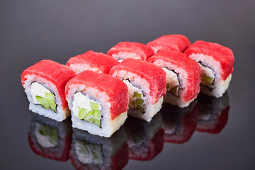 Philadelphia roll sushi with tuna, cucumber and cream cheese on black background for menu. Japanese food