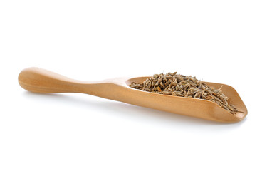 caraway seeds in wood scoop on white background