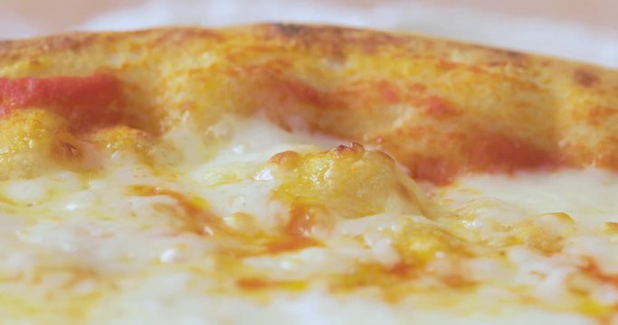 Macro pizza margherita napoletana con mozzarella che ribolle dopo l'uscita dal forno a legna su un tagliere.