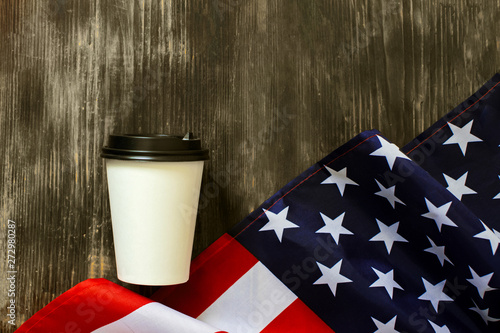 American flag and coffee paper cup on a old wooden background.