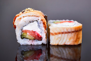 Philadelphia roll sushi with smoked eel, avocado, tuna and cream cheese on black background for menu. Japanese food