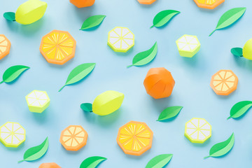 Fruit made of paper. Blue background. There's room for writing. Tropics. Flat lay. Orange, lemon.