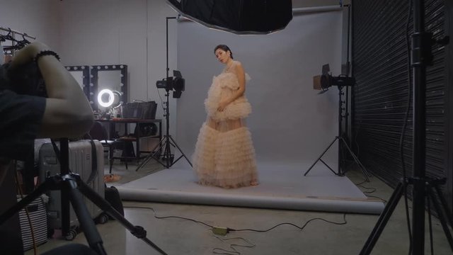 Studio photo shoot with high fashion model woman in pink ruffle dress