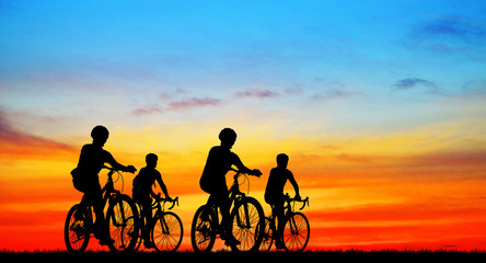 Silhouette group friend  and bike relaxing on blurry sunset background.