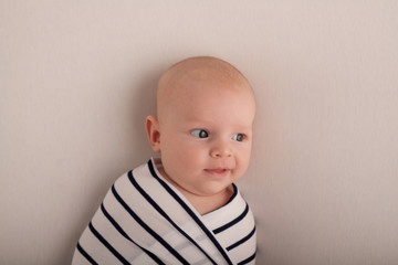 Portrait of a two-month boy on a bed with a diaper