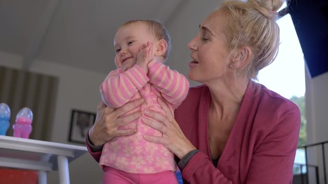 Slow motion shot of a smiling mother holding her baby daughter