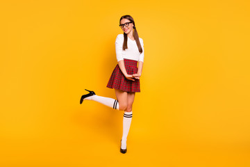 Fototapeta na wymiar Full length body size view of her she nice attractive winsome lovely lovable cheerful cheery positive girl wearing uniform having fun isolated over bright vivid shine yellow background