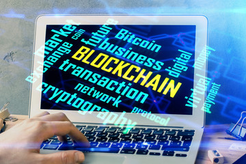 Crypto currency theme hologram with businessman working on computer on background. Concept of blockchain. Double exposure.