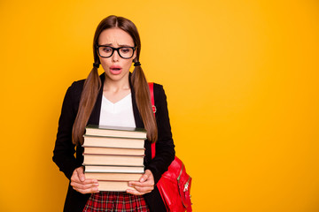 Portrait of her she nice attractive worried confused desperate girl holding in hands many different heavy book classes courses highschool isolated over bright vivid shine yellow background