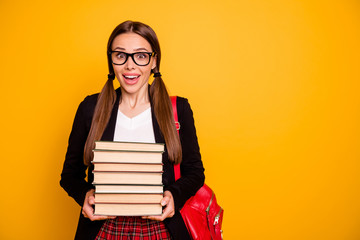 Portrait of her she nice-looking lovely attractive cheerful cheery girl holding in hands many heavy scientific book classes courses prepare exam test isolated over bright vivid shine yellow background