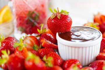 Dipping of tasty strawberry into bowl with chocolate
