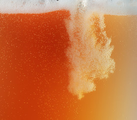 Close up view of floating bubbles in golden colored beer background. Texture of cooling summer's...