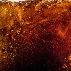 Close up view of the ice cubes in dark cola background. Texture of cooling sweet summer's drink with foam and macro bubbles on the glass wall. Fizzing or floating up to top of surface. - obrazy, fototapety, plakaty