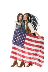 full length view of two bisexual hippie girls holding american flag and embracing isolated on white