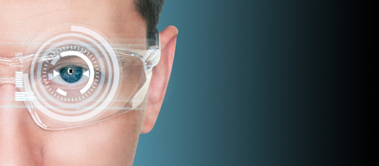 A man in augmented reality glasses with a head up display. Digital transformation and smart industry concept.	