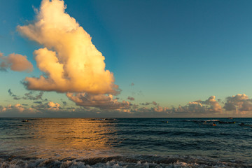 Huge cloud cumulus nimbus over the sea during sunset. Water calm. Vacation landscape.