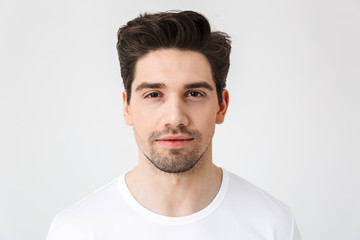 Obraz premium Serious concentrated young man posing isolated over white wall background.