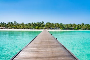 Foto op Plexiglas Houten pier op een luxe resort op een tropisch eiland © eyetronic