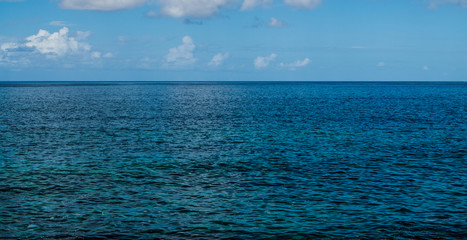 Obraz premium Atlantic ocean seascape, with afternoon sunlight, blue sky and some clouds, Tenerife, Canary islands, Spain