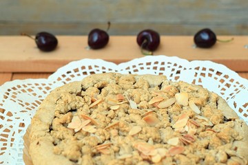 Crumble cake with integral flavour on white napkin and some decorative cherries