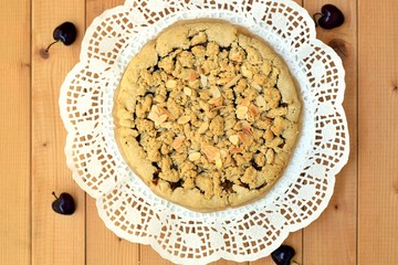 Crumble cake with integral flavour on white napkin and some decorative cherries
