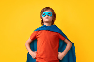 Confident little superhero in heroic pose - obrazy, fototapety, plakaty