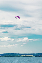 A kiteboarder is pulled across water by a power kite. Kitesurfer high in flight