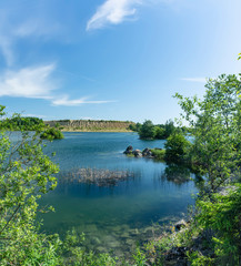 Obraz premium Sunny summer day at an abandoned quarry for the extraction of stone.