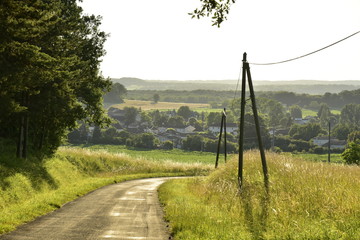 Route de campagne brillant sous la lumi&egrave;re du soir et le village de Champagne dans la vall&eacute;e de la Lizonne au P&eacute;rigord Vert
